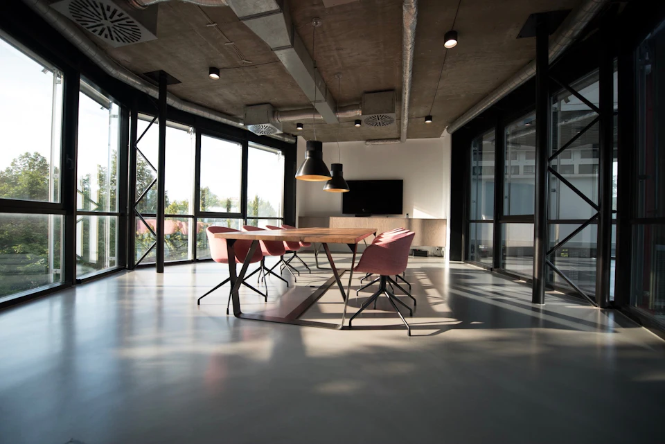 A modern office with glass walls and a meeting table