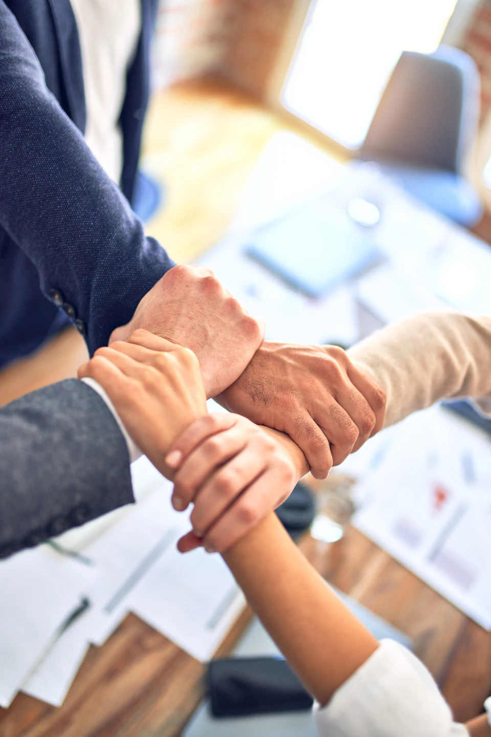 Colleagues joining hands in a show of unity